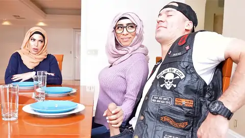 Hijab-wearing woman providing a hj from under the table