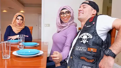 Hijab-wearing girl giving a hand job from under the table